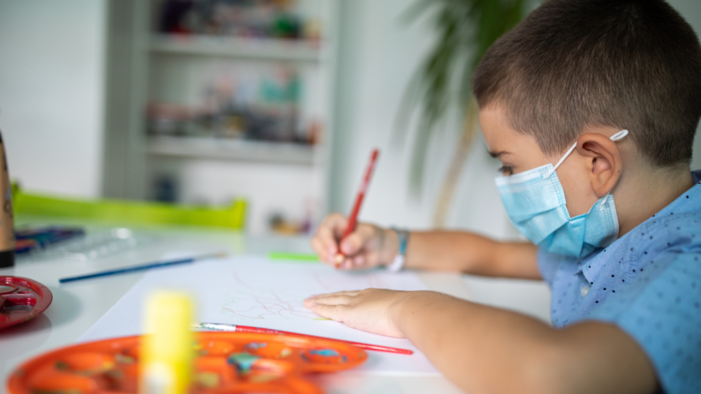 Child doing art in a mask